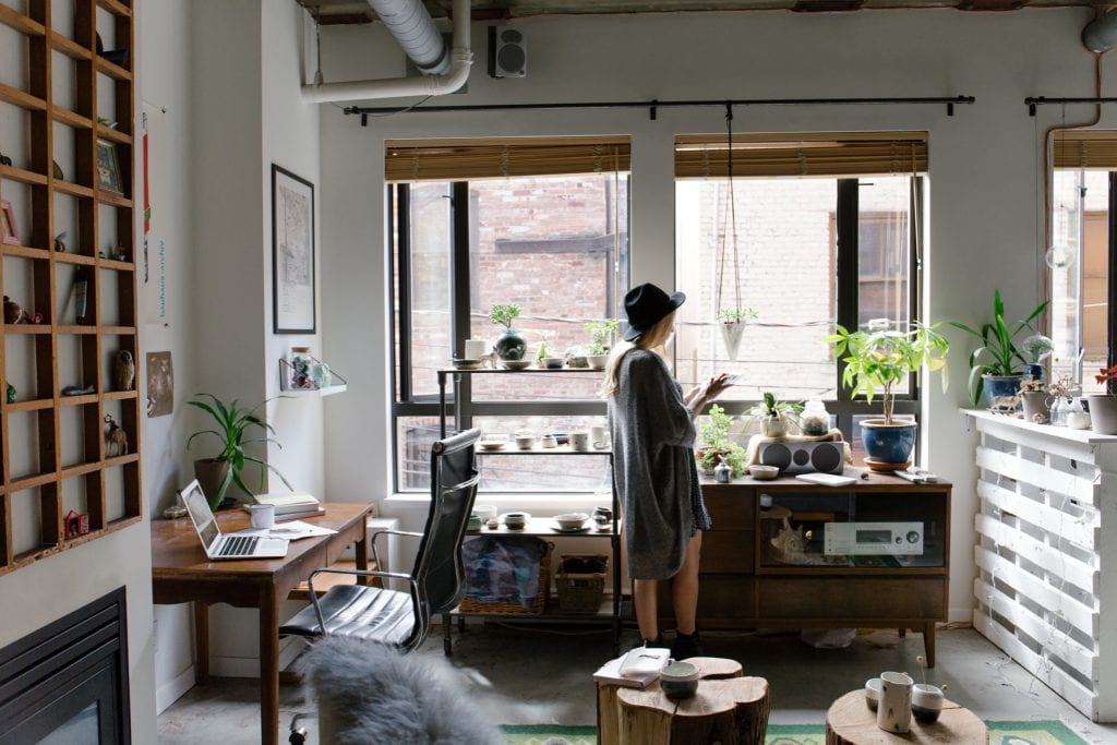 young woman in work studio alone next to window