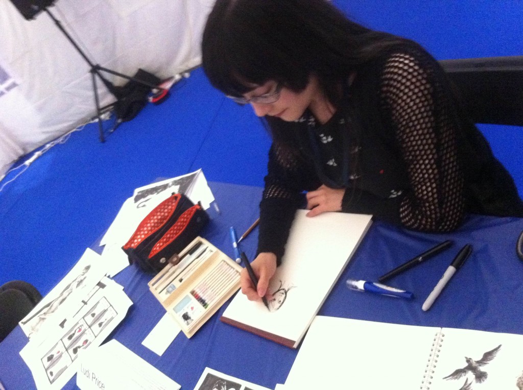 Me drawing in the Loncon 3 fan activity tent.